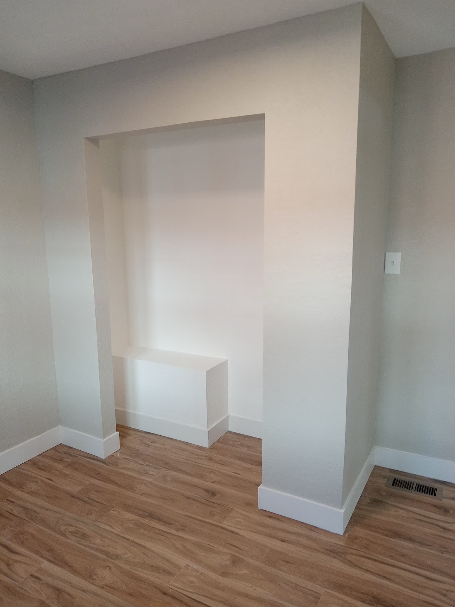 The same opening finished as a clean plastered alcove with a built in bench